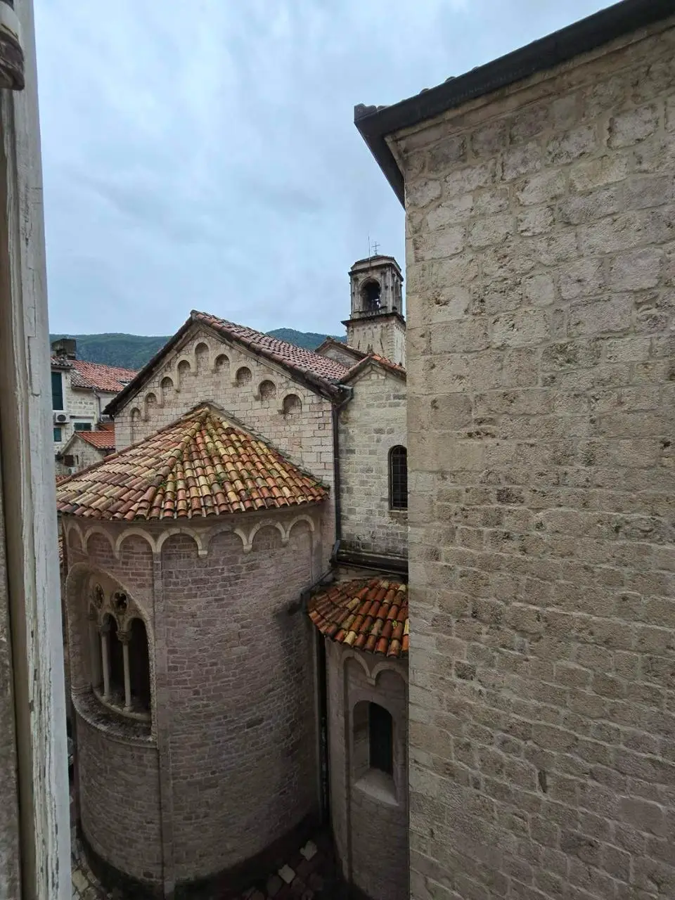 Stone church buildings with red tile roofs and bell tower
