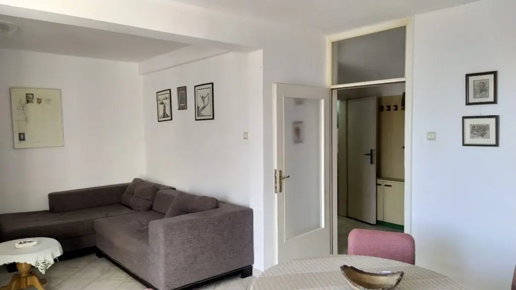 Living room with gray sectional sofa, round table, and open doorway