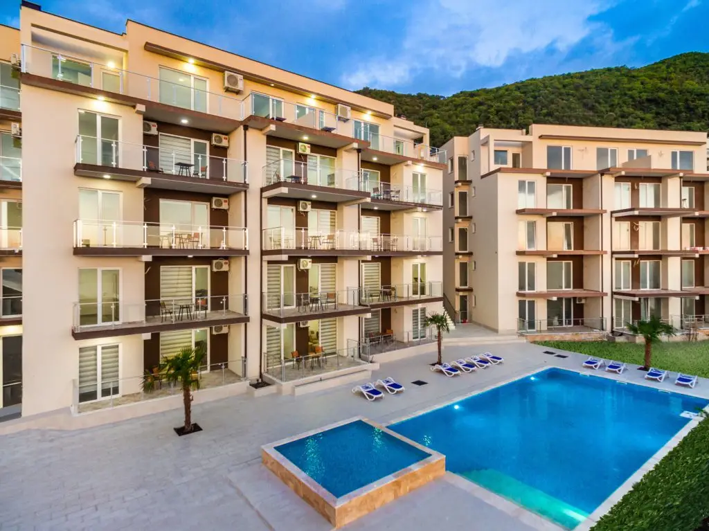 Apartment complex courtyard with swimming pool and lounge chairs at dusk