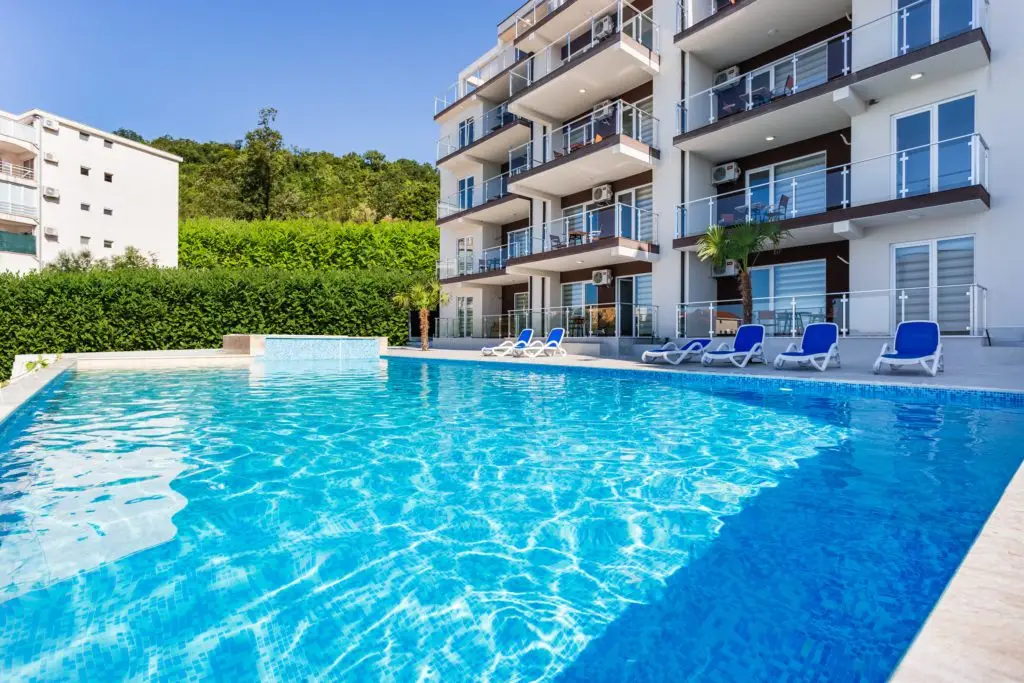 Outdoor swimming pool beside modern apartment building
