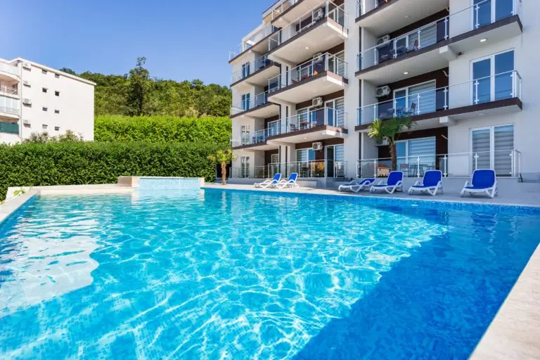 Outdoor swimming pool beside modern apartment building