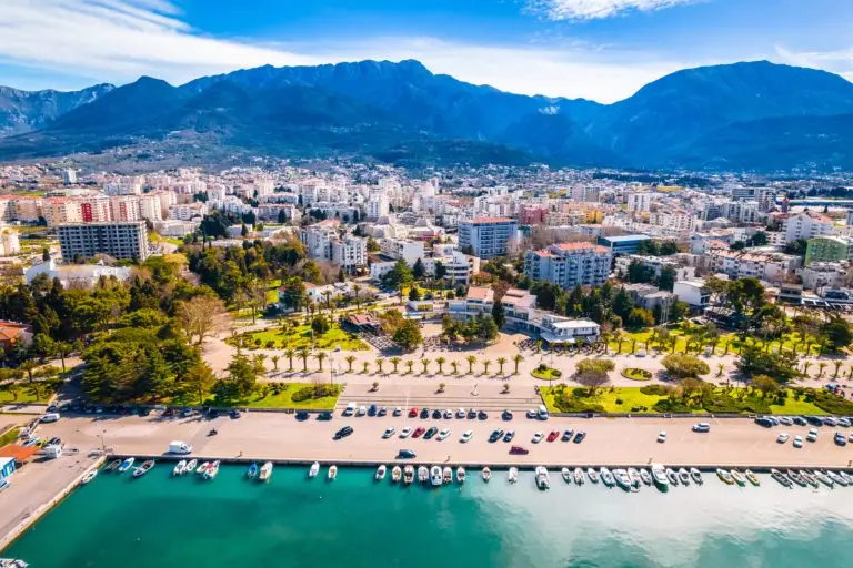 Aerial view of waterfront city, marina, and mountains