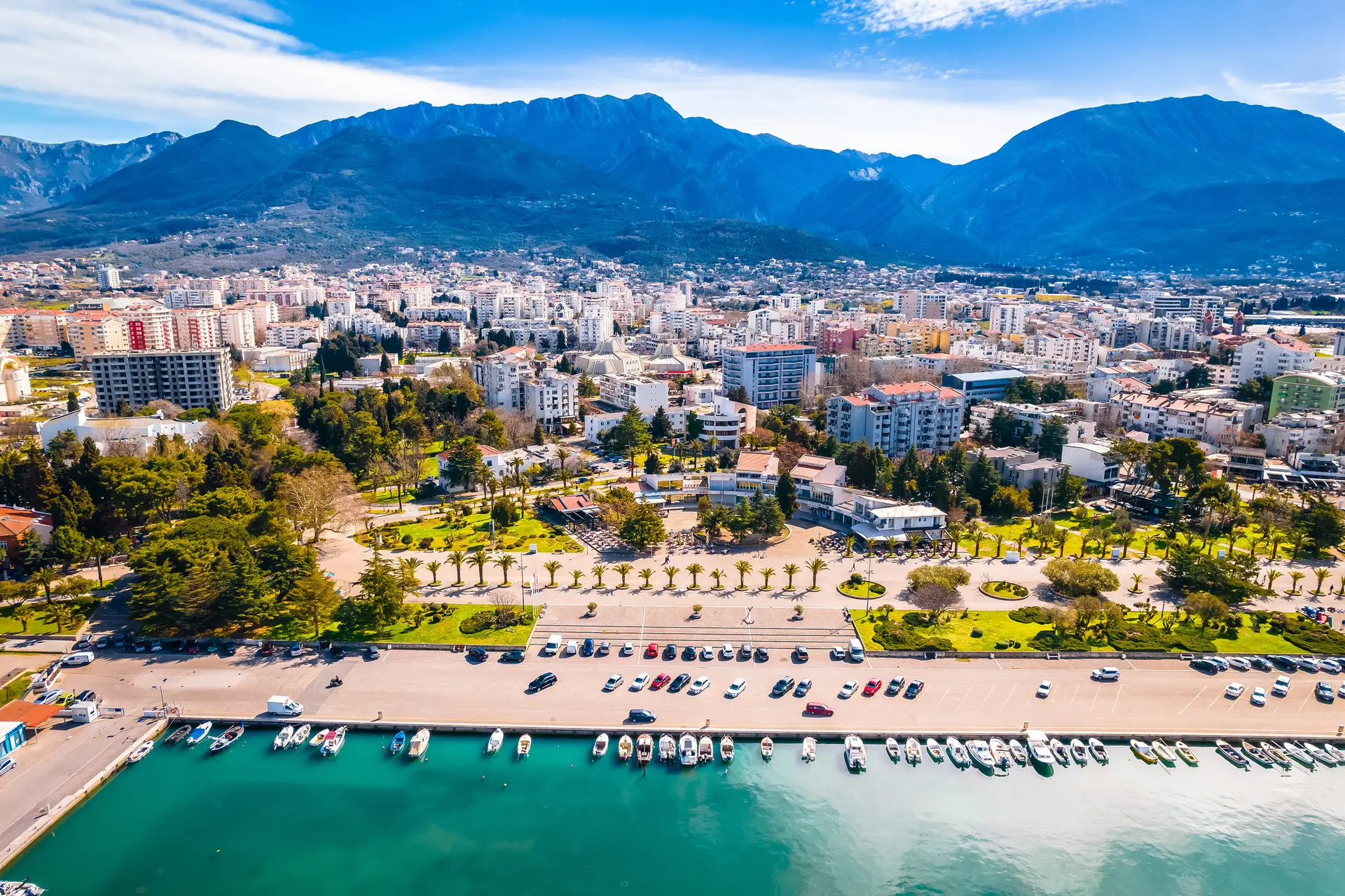 Aerial view of waterfront city, marina, and mountains