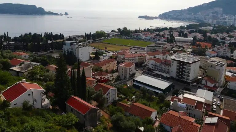 Aerial view of Budva coastline with red-roofed buildings and sea