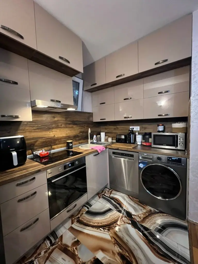 Compact kitchen with beige cabinets and patterned floor tiles