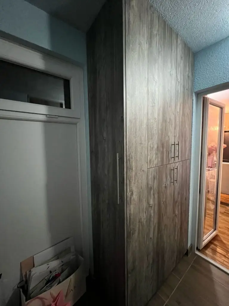 Hallway with built-in wood wardrobe and open doorway