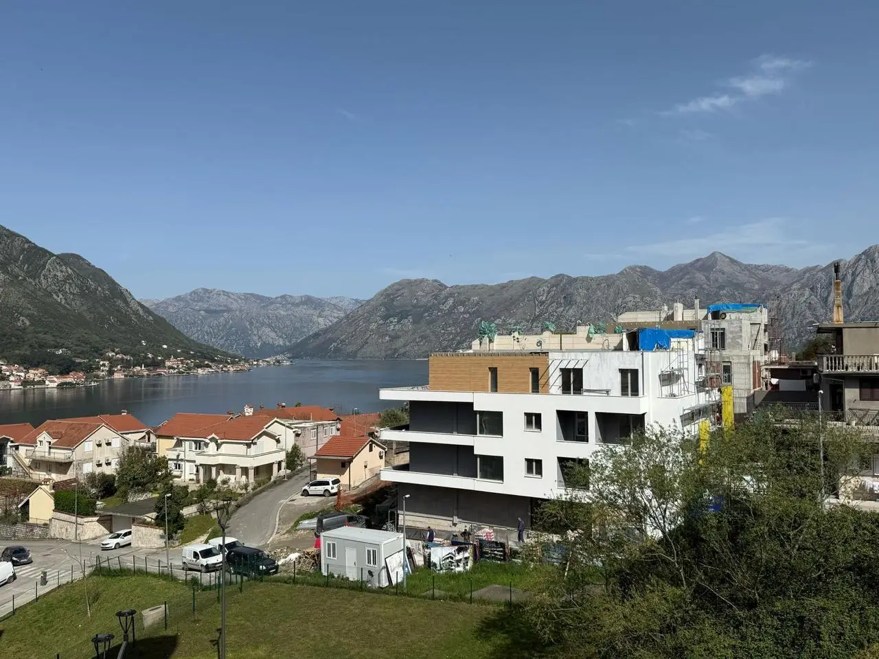 Modern building under construction overlooking bay and mountains