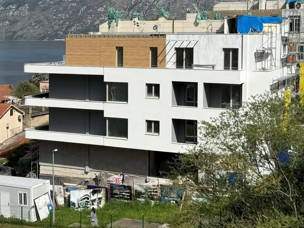 Modern apartment building under construction by the water