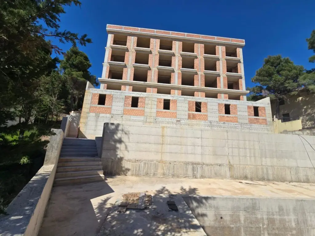 Unfinished multi-story brick and concrete building with exterior stairs