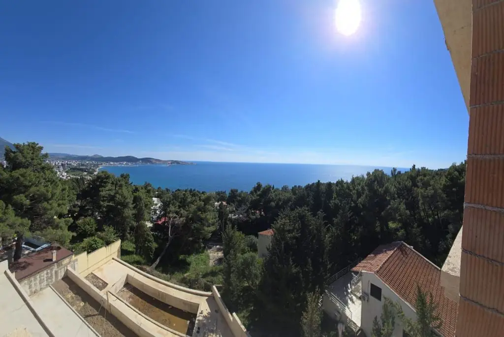 Sea view over pine trees and buildings from a balcony