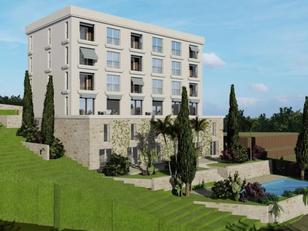 Modern apartment building on a green hillside with pool
