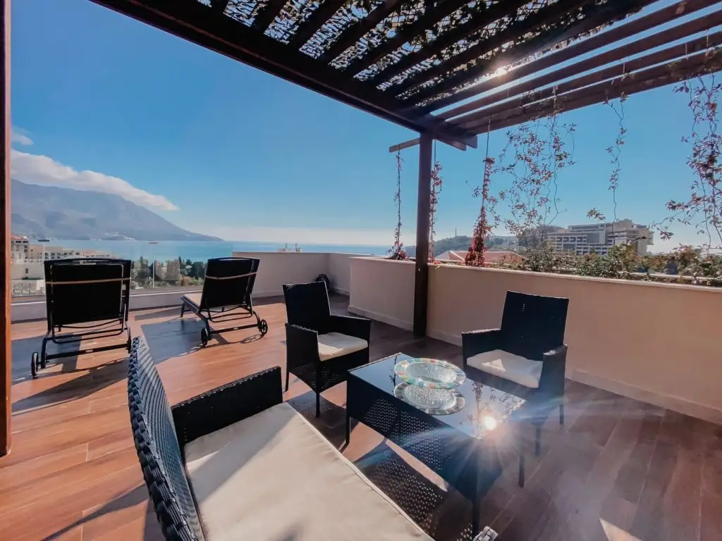 Terrace with black chairs, glass table, and sea view
