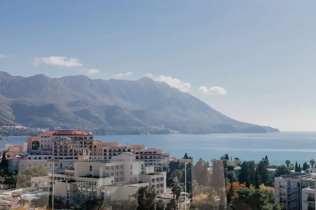 Seaside buildings with bay and mountains in background