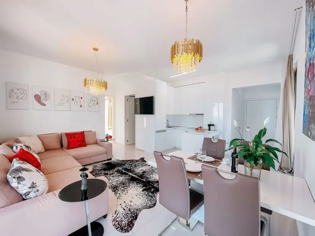 Modern open-plan living room with sofa, dining table, and kitchenette