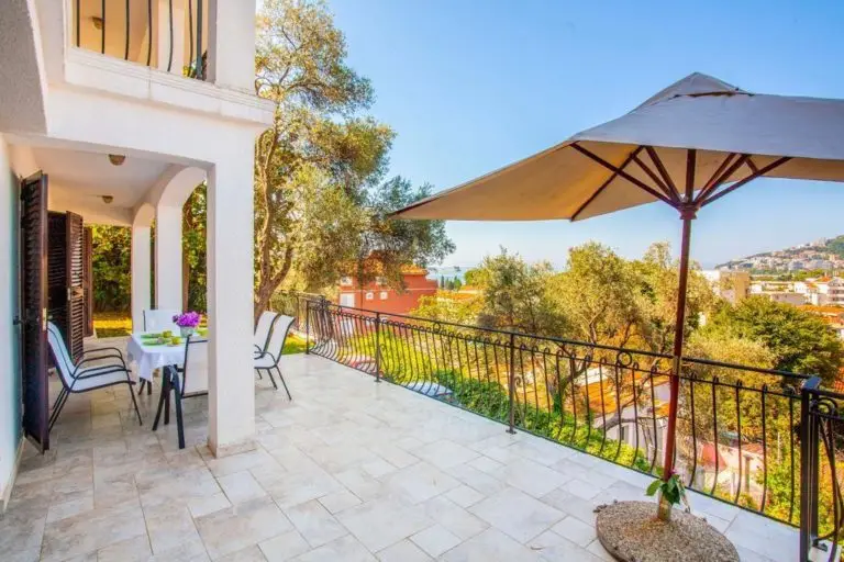 Villa terrace with table, chairs, umbrella, and sea view