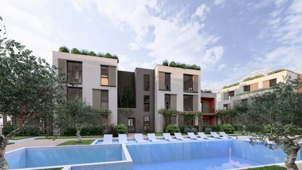 Modern apartment buildings beside an outdoor pool with loungers