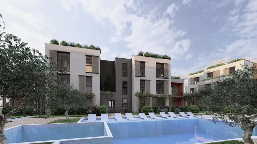 Modern apartment buildings beside outdoor swimming pool with lounge chairs