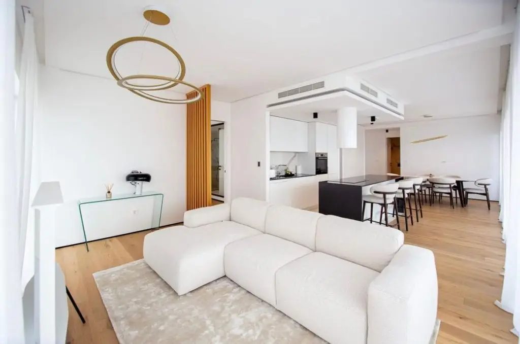Modern open-plan living room with white sectional and kitchen island