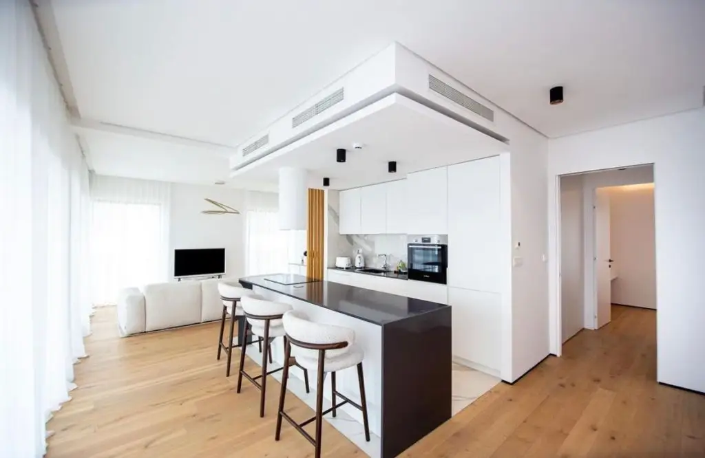 Modern white kitchen and living room with island stools