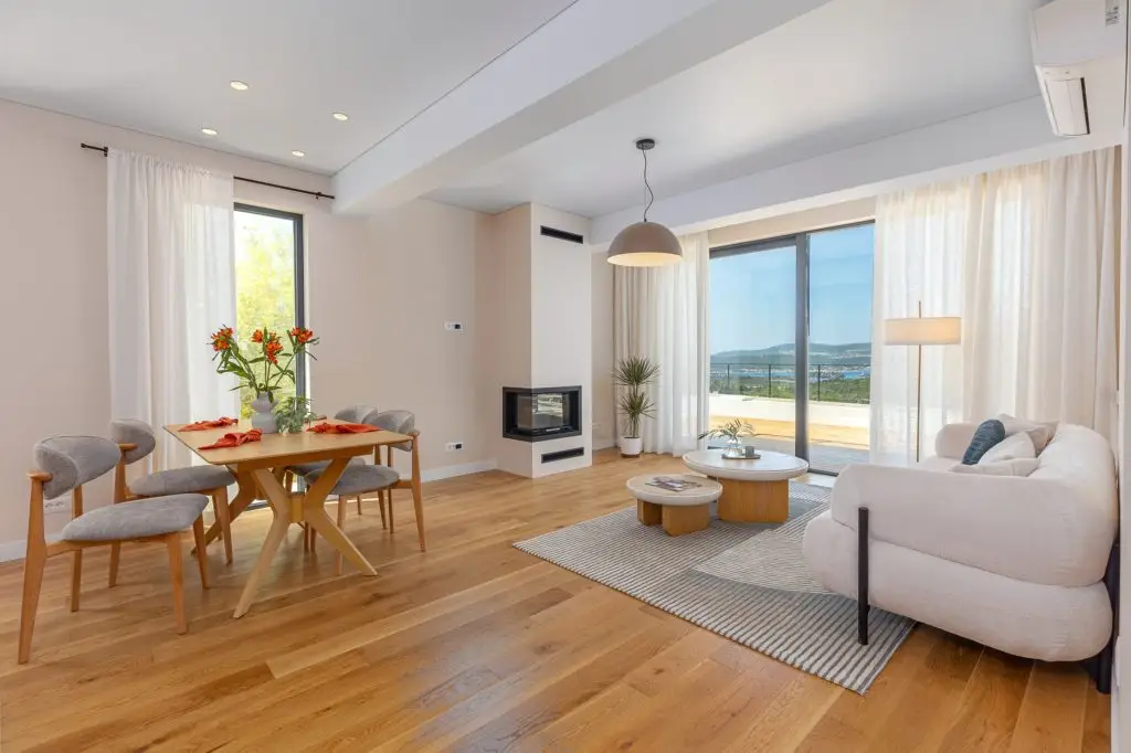Modern living-dining room with sofa, fireplace, and terrace view