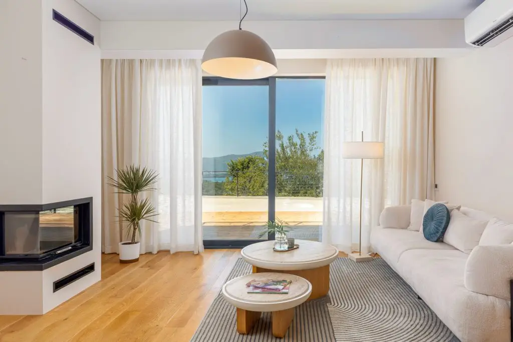 Modern living room with fireplace, sofa, and sea view
