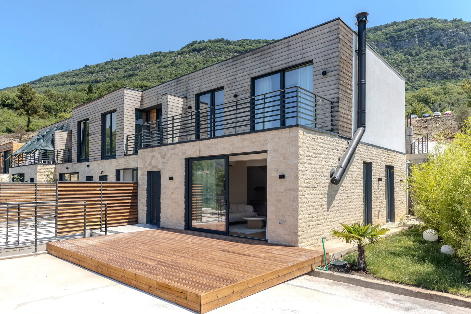 Modern two-story townhouse with wooden deck and balcony
