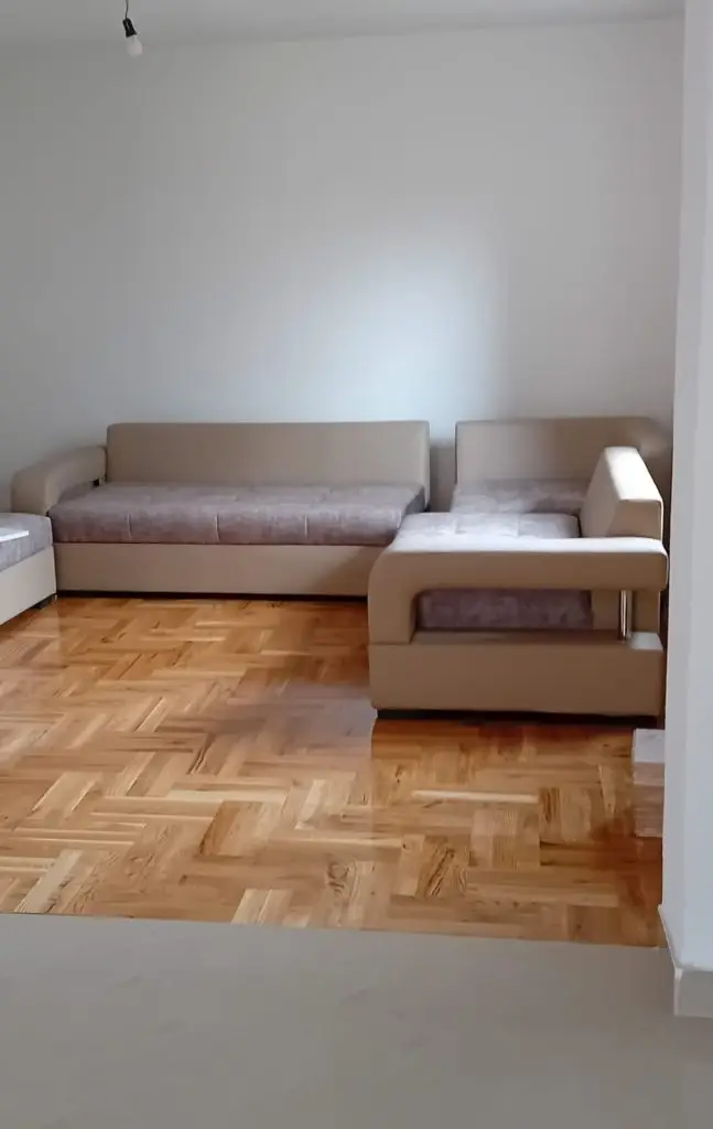 Living room with two beige sofas and parquet floor