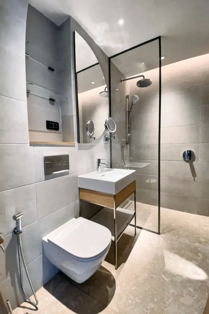 Modern bathroom with wall-mounted toilet, sink vanity, and glass shower