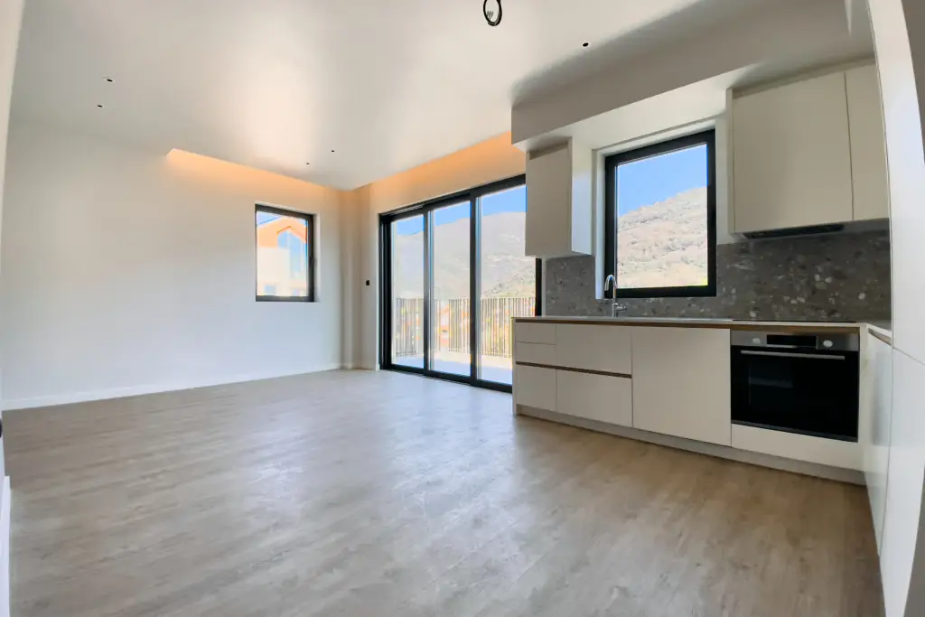 Empty modern kitchen and living room with sliding glass doors
