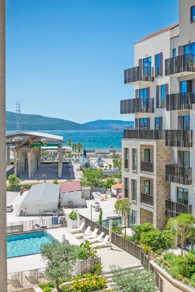 Apartment building with balconies, pool, and sea view