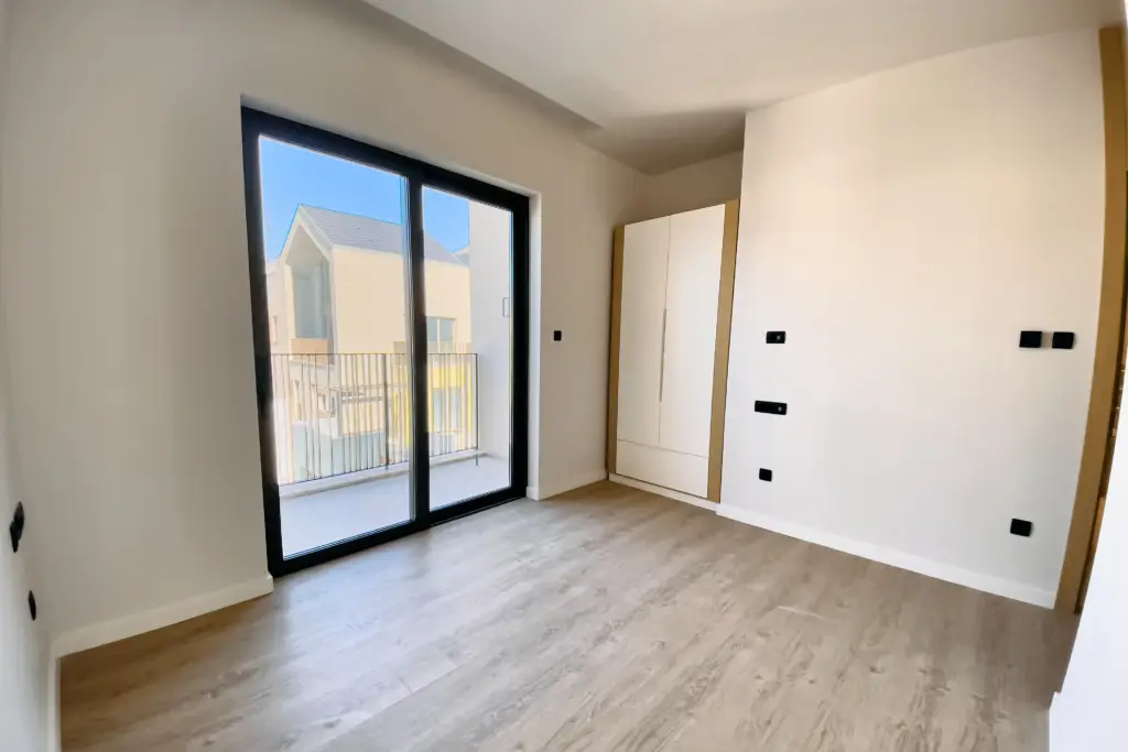 Empty room with sliding glass door, built-in wardrobe, and light wood floor