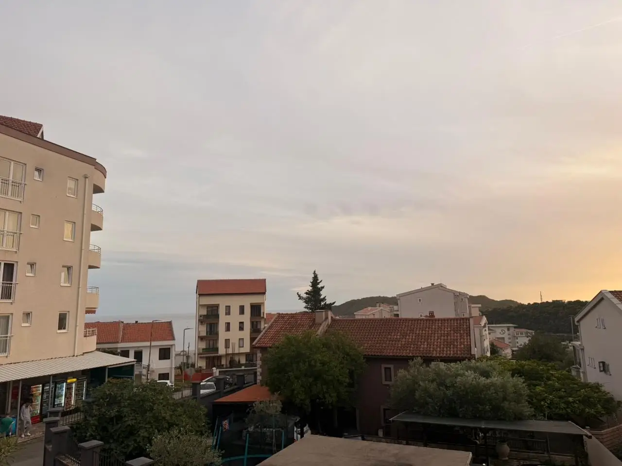 Urban residential buildings at sunset with distant sea view