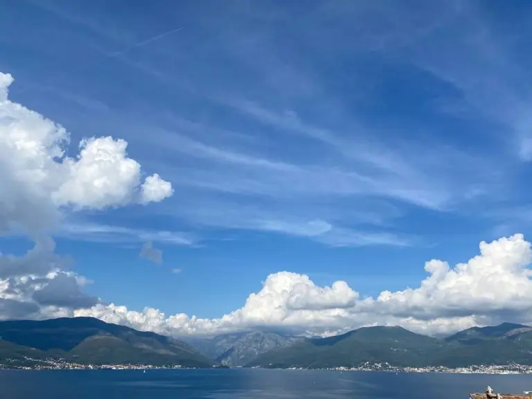 Blue sky over calm bay and mountains
