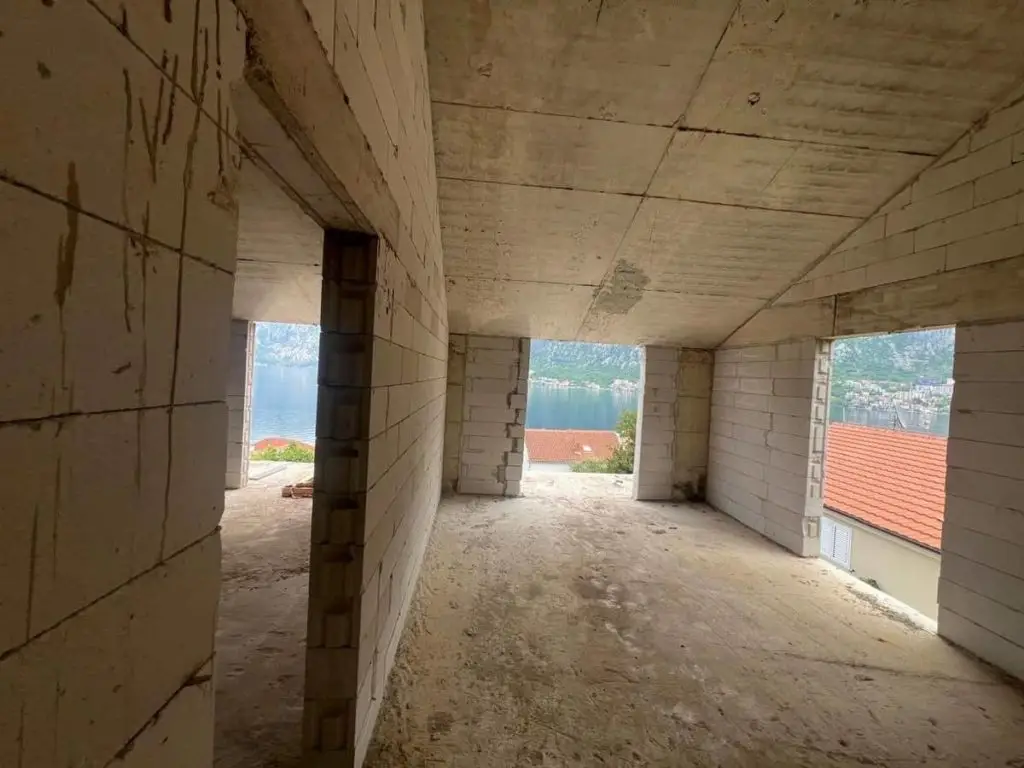 Unfinished concrete room with windows overlooking the bay