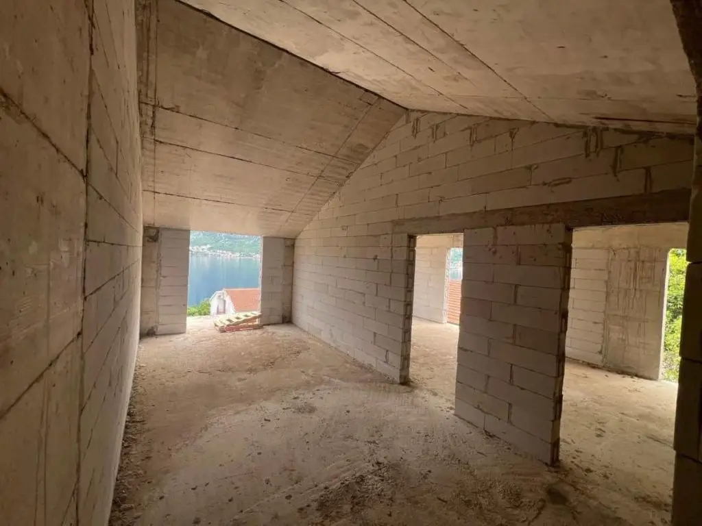 Unfinished concrete block interior with sea view through openings