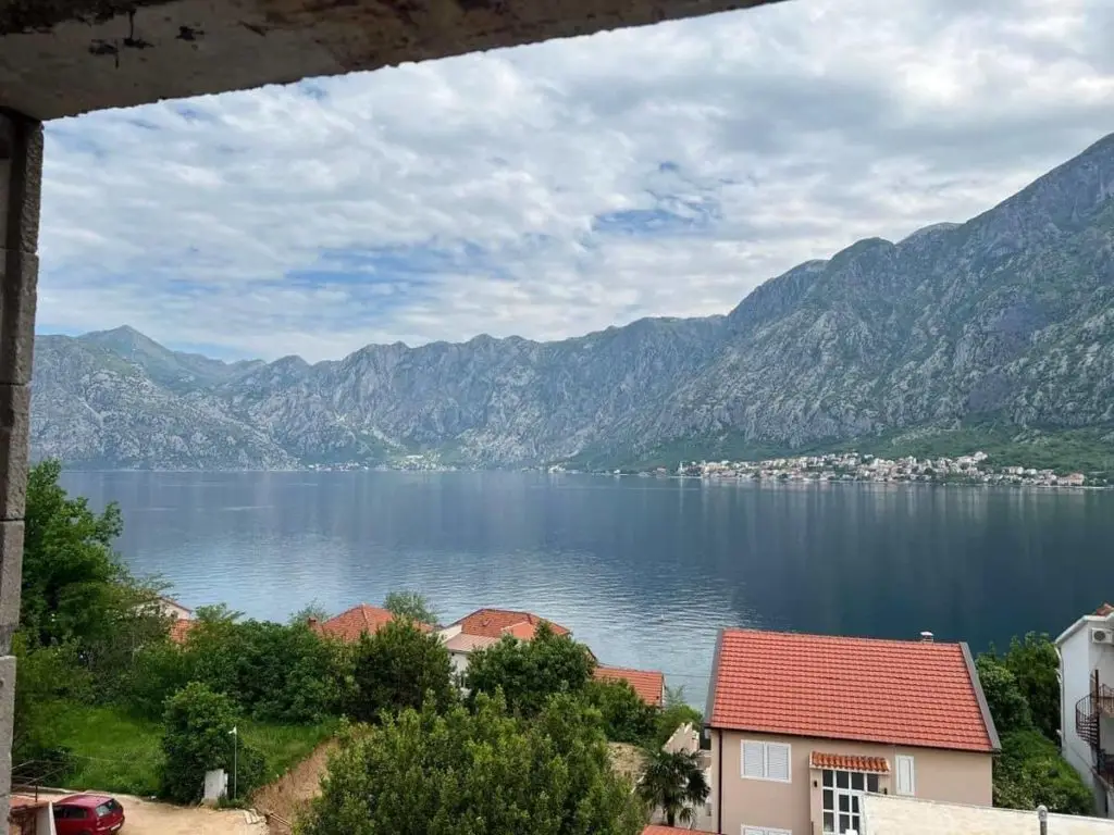 Bay with mountains, houses, and cloudy sky