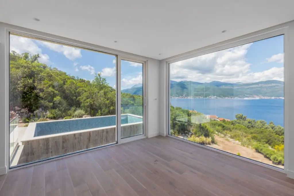 Empty room with floor-to-ceiling windows and sea view