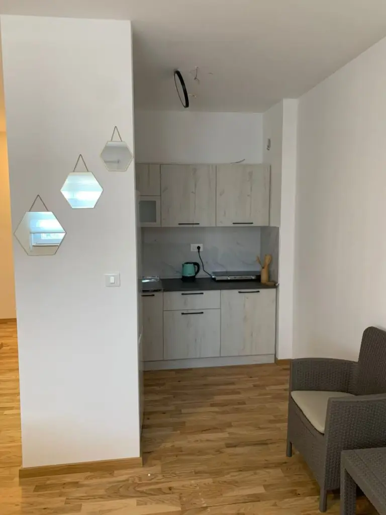 Compact kitchen nook with white cabinets and wooden floor
