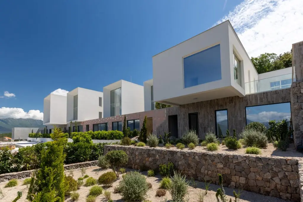 Modern white villa with landscaped garden and blue sky