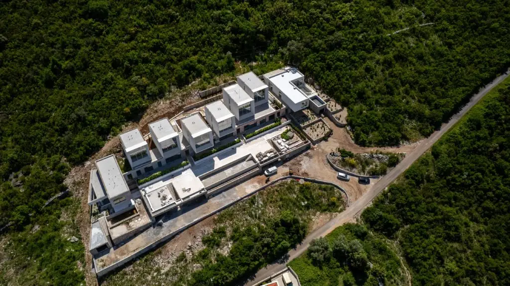 Aerial view of a modern white villa surrounded by greenery