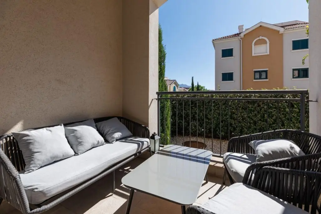 Balcony with black wicker seating and glass table