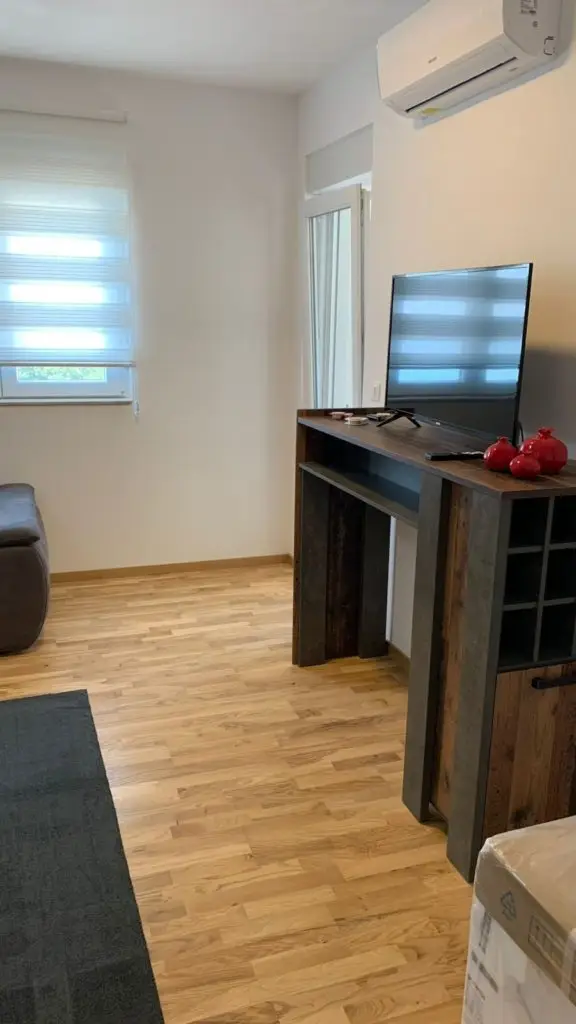 Modern living room with TV, bar table, and air conditioner