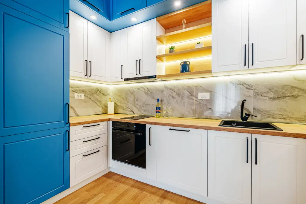 Modern kitchen with blue and white cabinets and marble backsplash