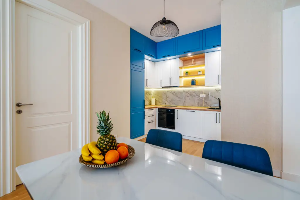 Dining table with fruit bowl in blue-and-white kitchen