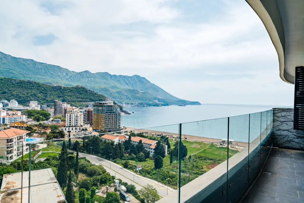 Balcony view over seaside town, mountains, and calm sea