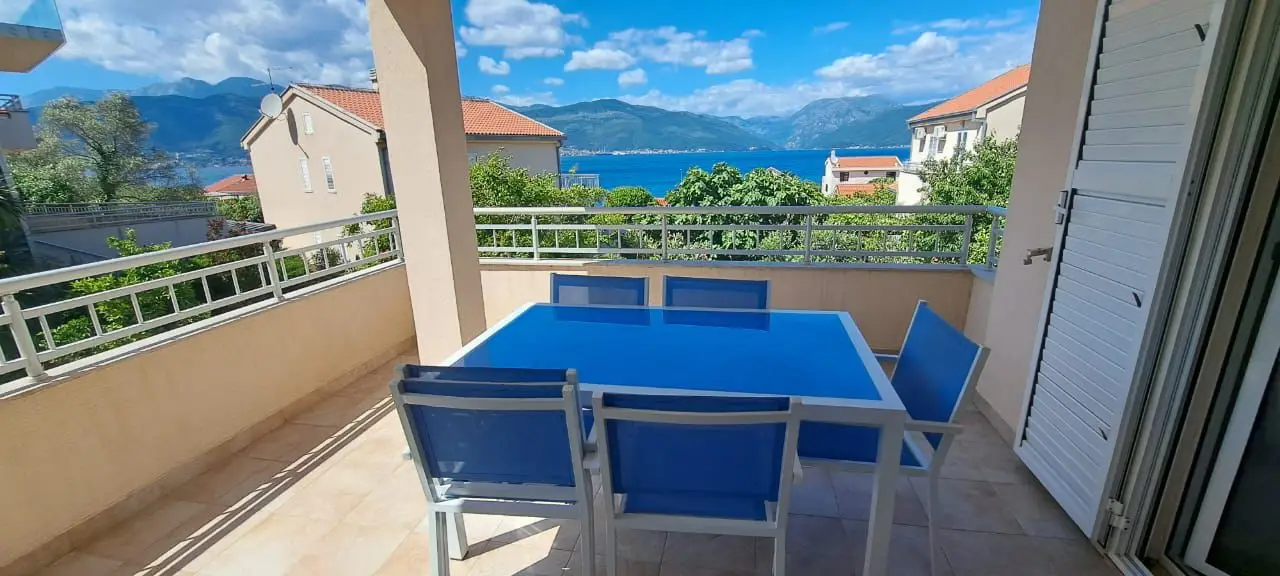 Terrace with blue table and chairs overlooking the sea