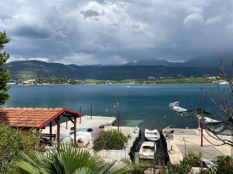 Bay with boats, mountains, and cloudy sky