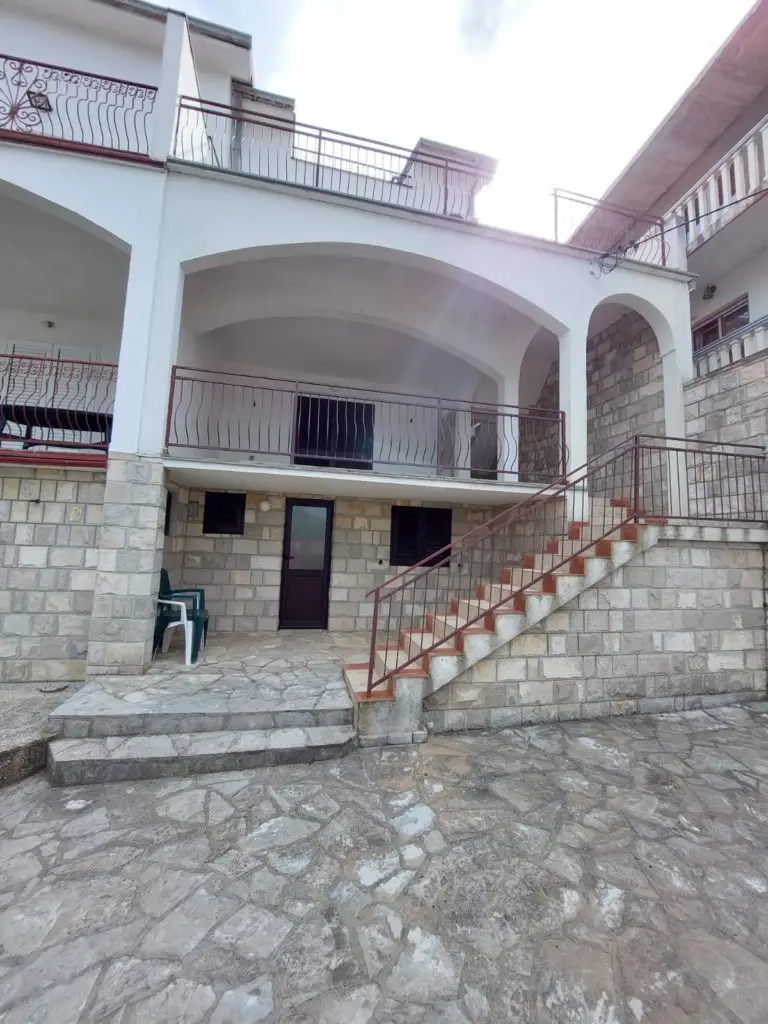 Stone-front house exterior with stairs and balconies