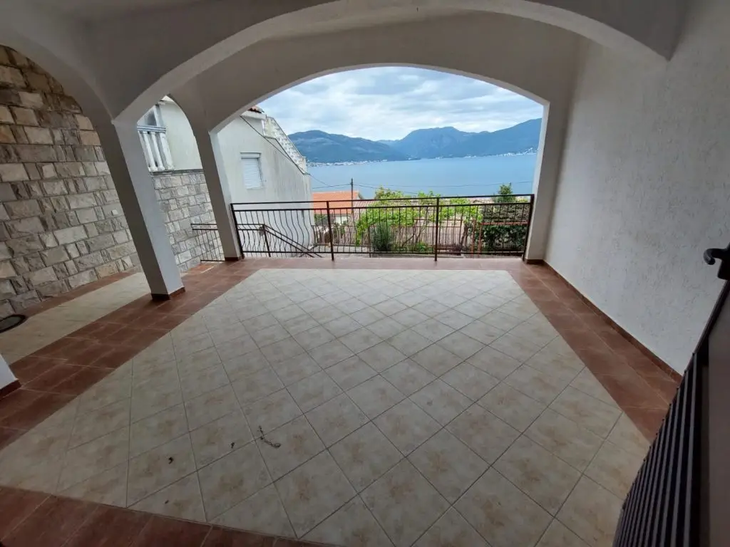 Covered tiled terrace with arched opening and sea view
