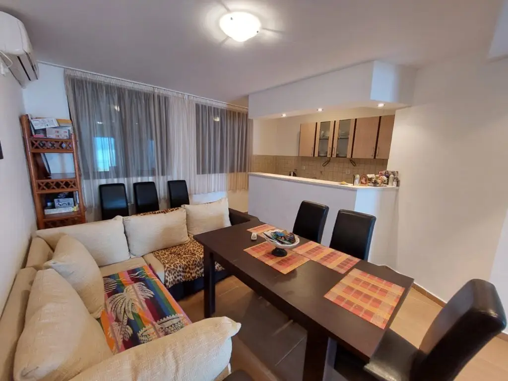 Living room with sofa, dining table, and kitchen counter